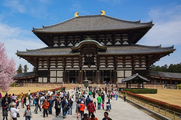 A Japanese building with a crowd of people standing in front of it.