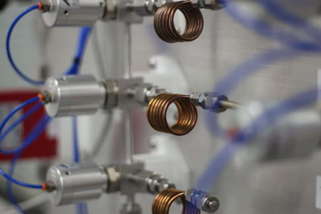 Copper tubing on a wall with switches and gauges to control scientific experiments